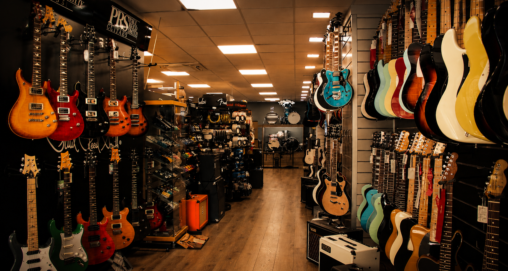 Interior de la tienda Musical Guima con guitarras eléctricas, amplificadores y equipos musicales en exposición.