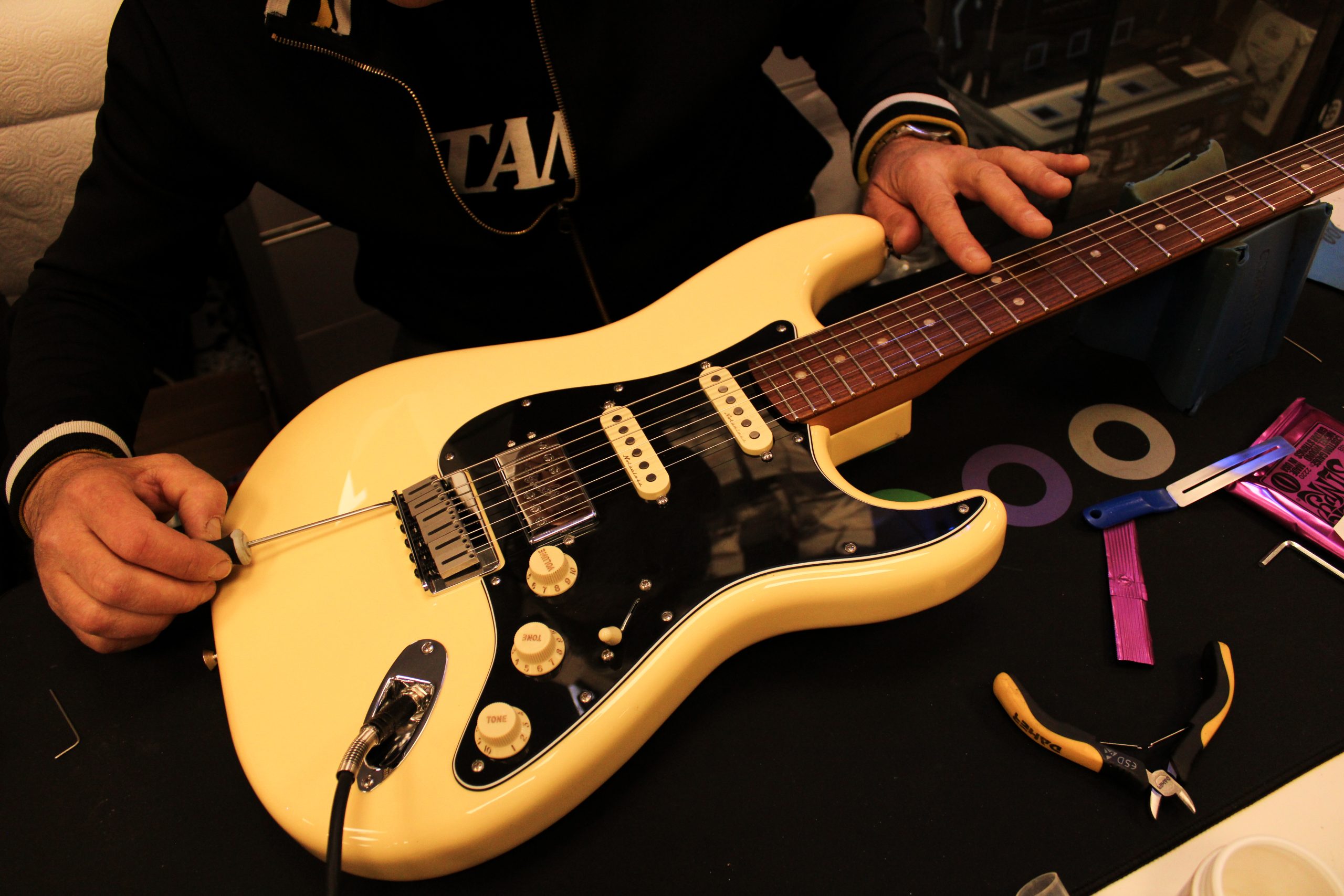 Técnico ajustando una guitarra eléctrica en Musical Guima.